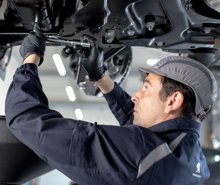 Mécanicien effectuant une vidange sur une Peugeot – révision constructeur à Valence, Drôme